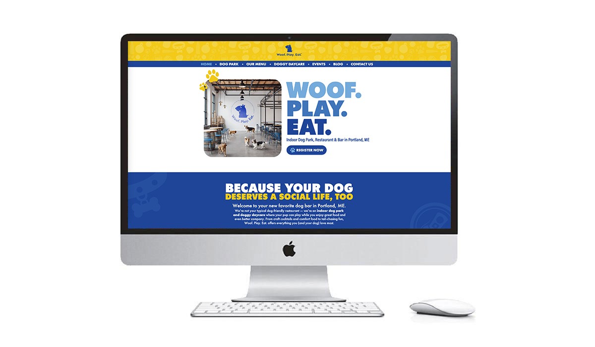 Woof. Play. Eat. consumer homepage displayed on iMac monitor